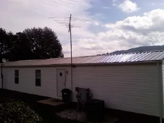 New metal roof on a single wide mobile home with a TV antenna in Crown Point