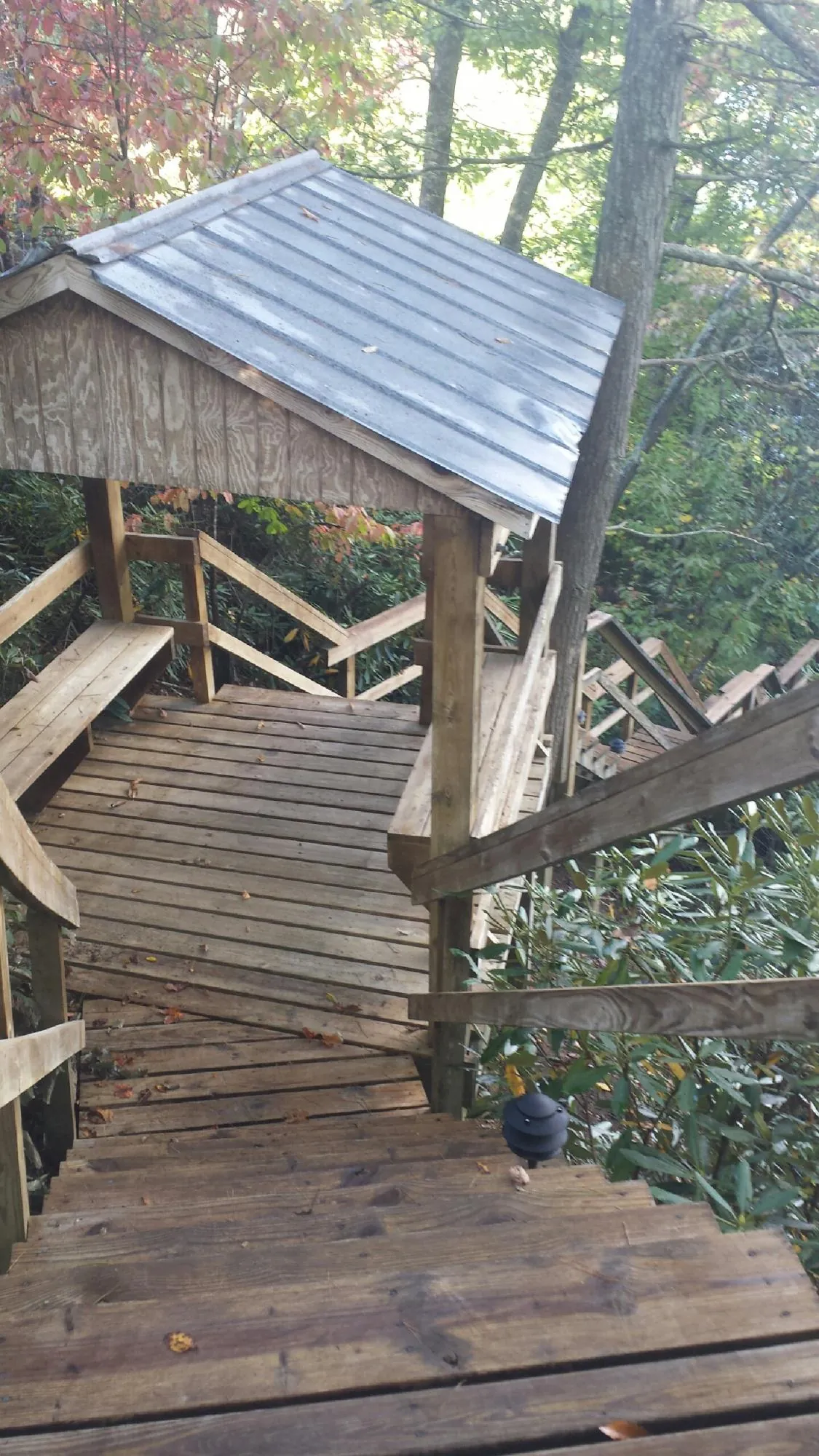 Metal roofed shelter over wooden steps on a wooded walkway — Skylight Repair & Installation work by our crew in Crown Point