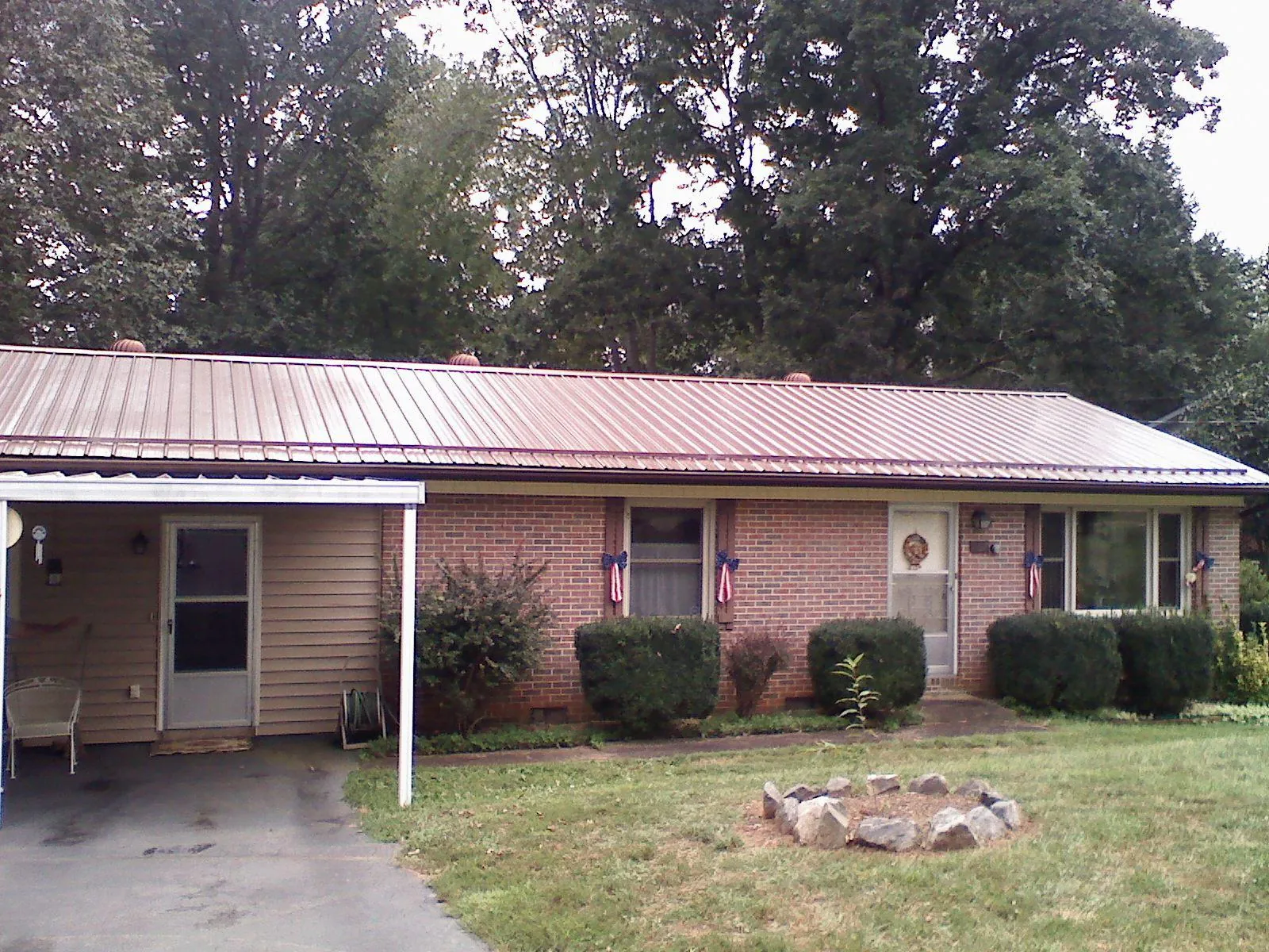 Bronze metal roof and carport on a brick ranch home — Roof Repair work by our crew in Crown Point